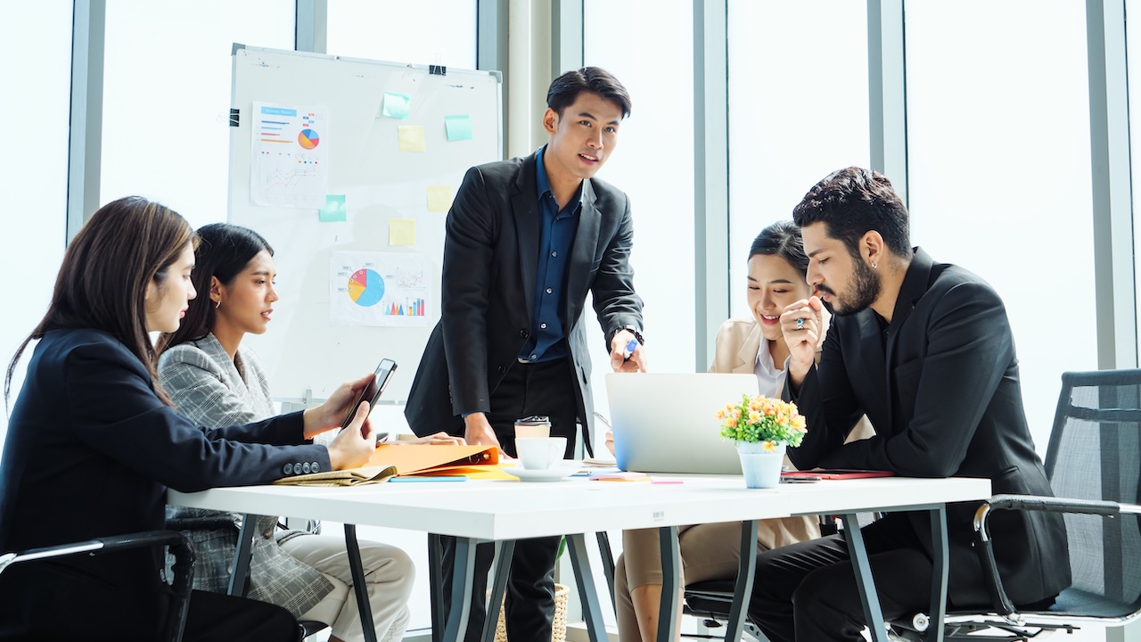 Asian,Business,Team,In,Modern,Office,Meeting,,Male,Leader,Presenting